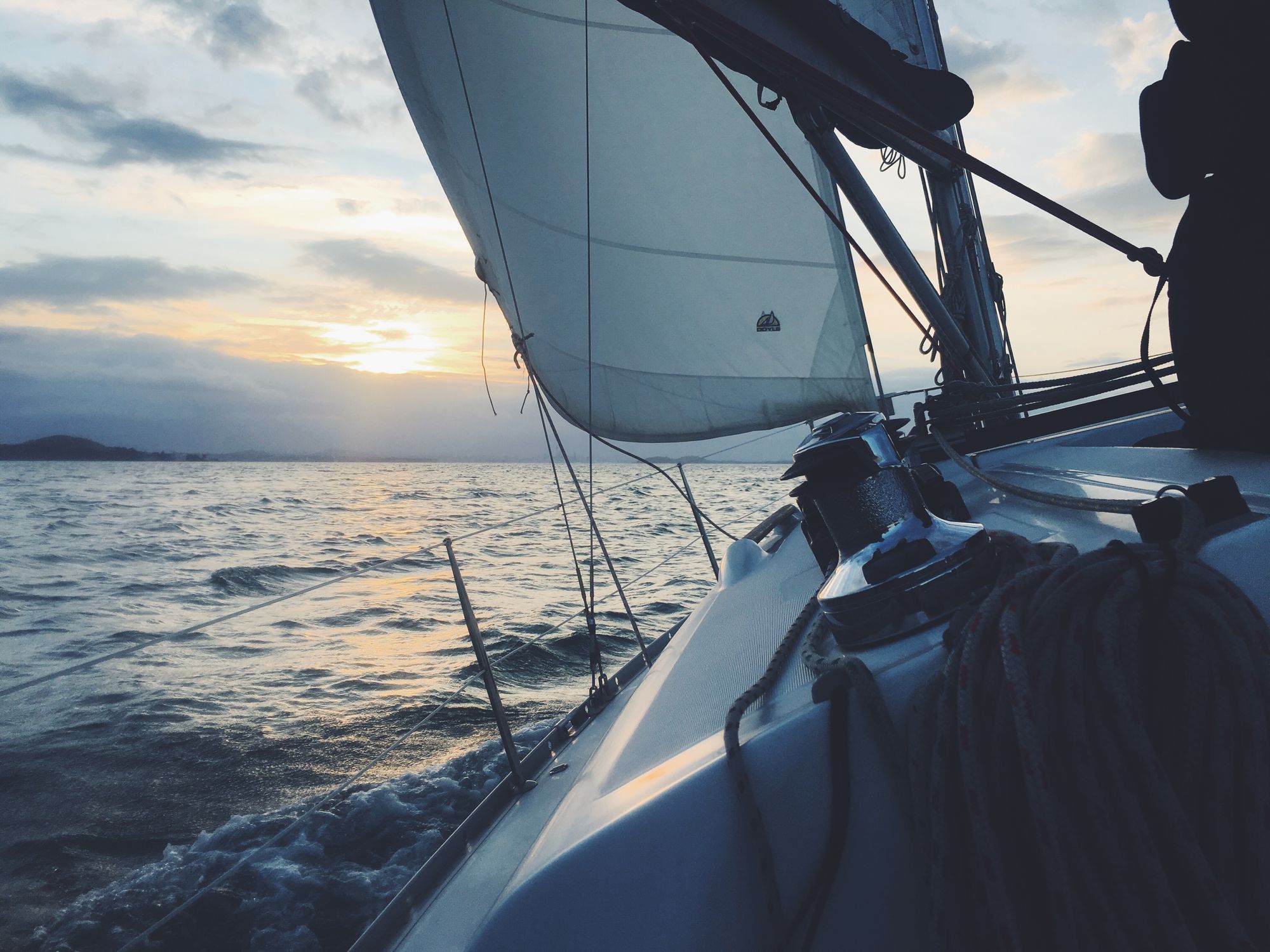 A yacht under sail on the Hauraki Gulf at golden hour