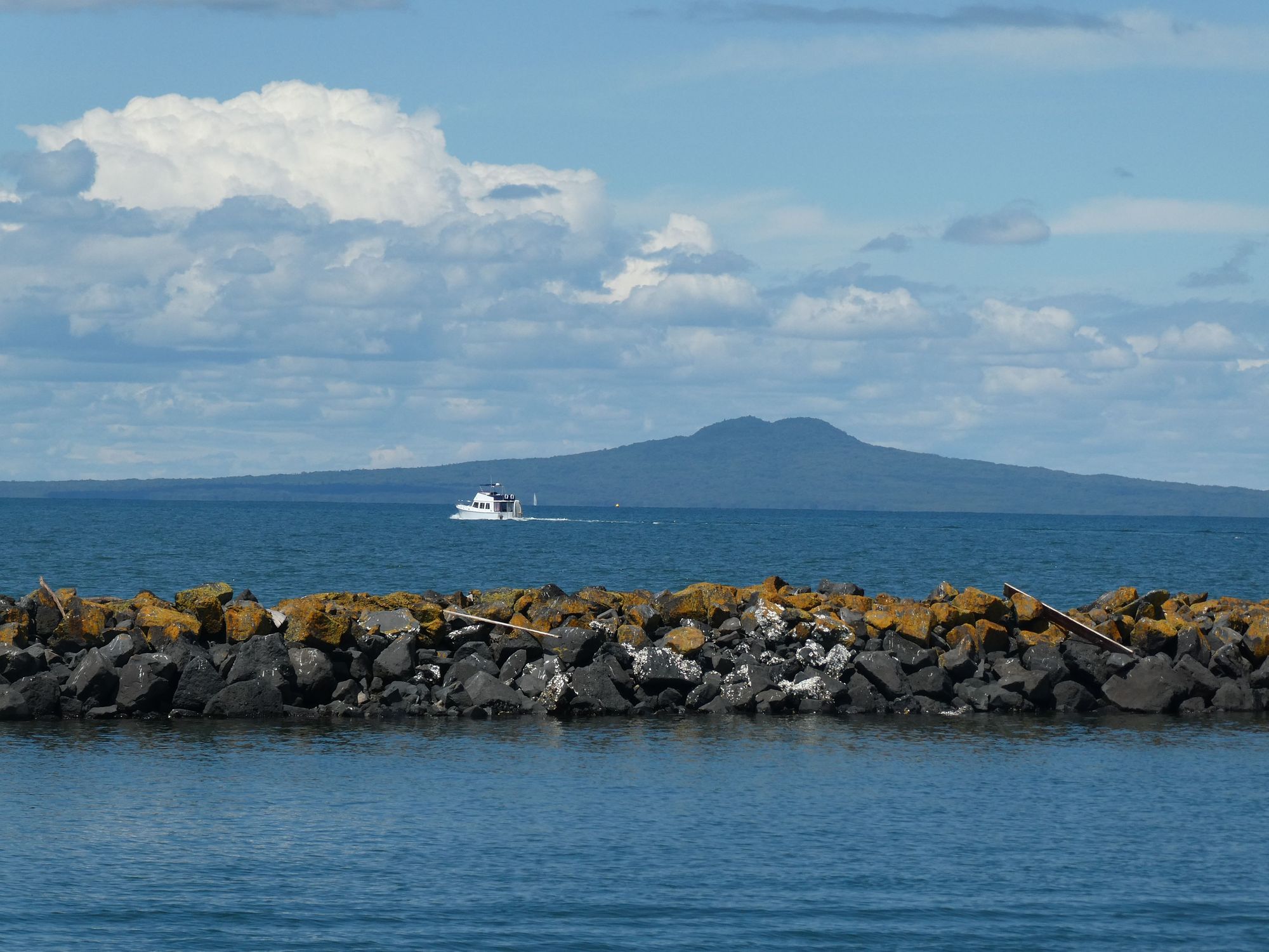 A boat crossing the harbour with Rangitoto behind
